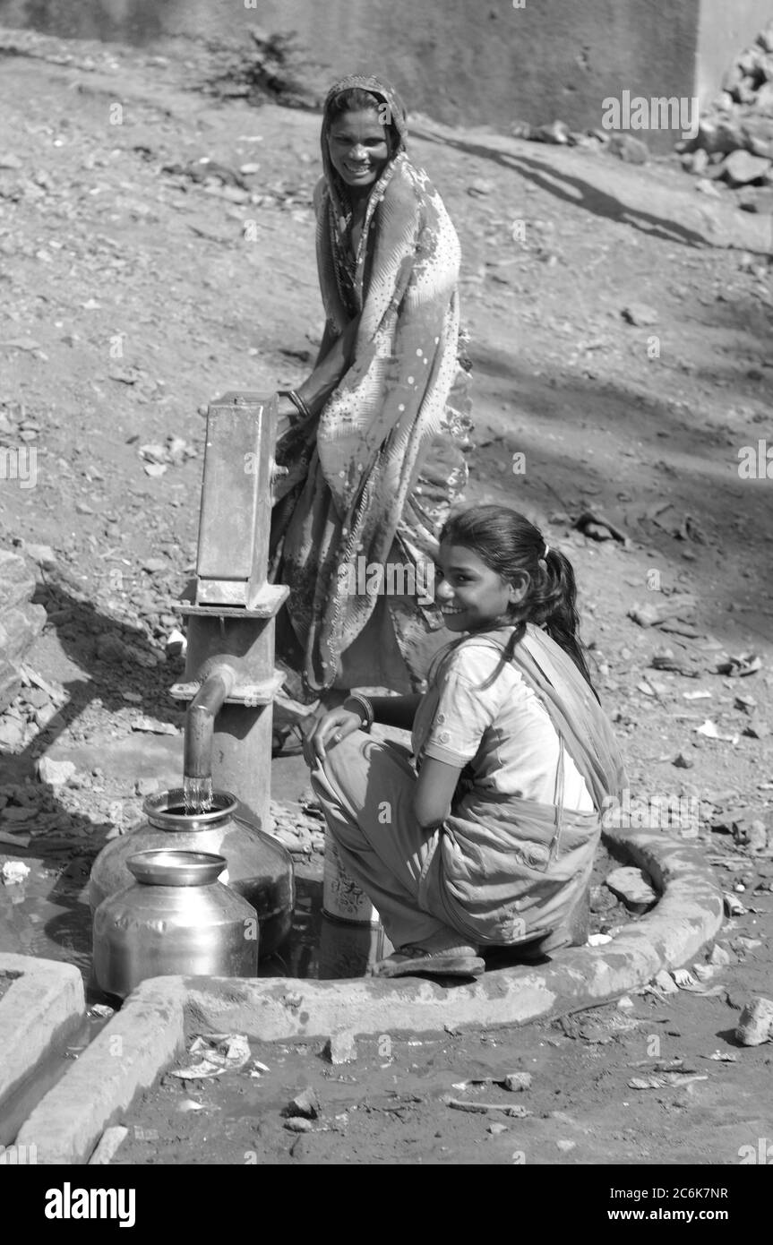 Zwei Junge Indische Frauen Am Wasserbrunnen Ihre Behälter Auffüllend Two Young Indian Women 