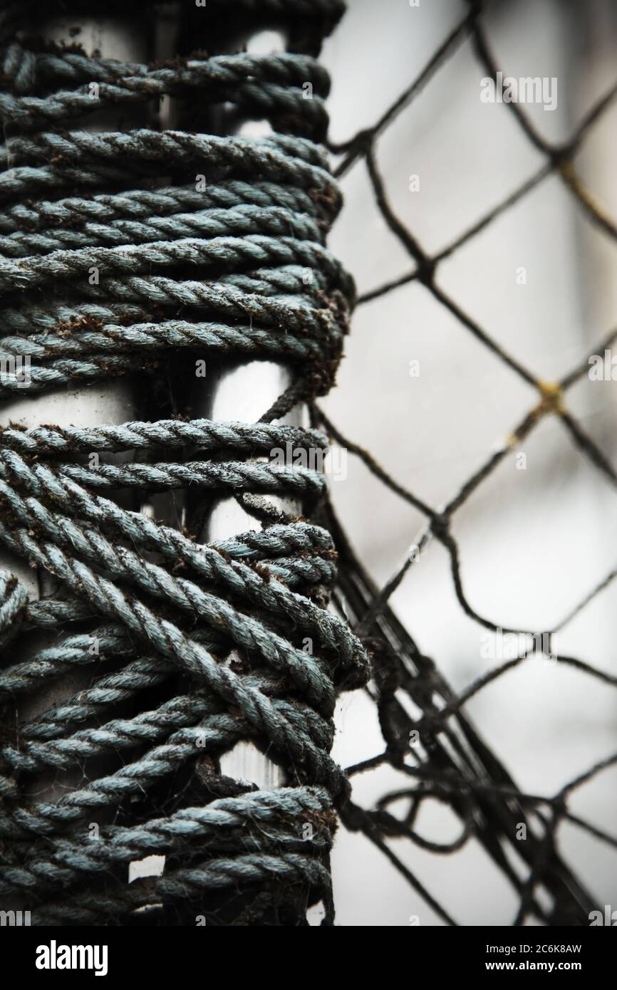 Old blue rope and chainlink fencing. Stock Photo