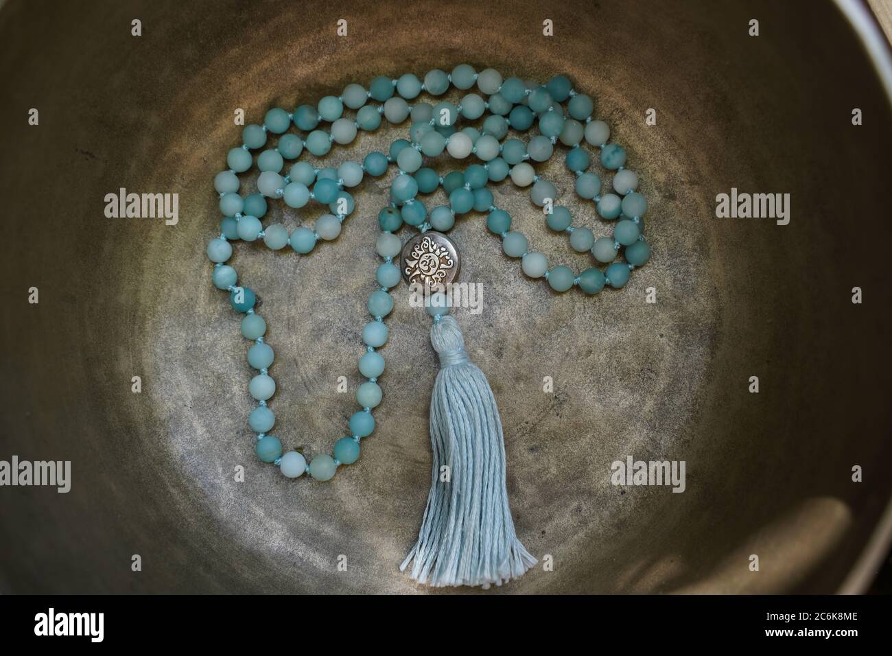 Tibetan singing bowl close up with beautiful turquoise Mala for soundhealing Stock Photo