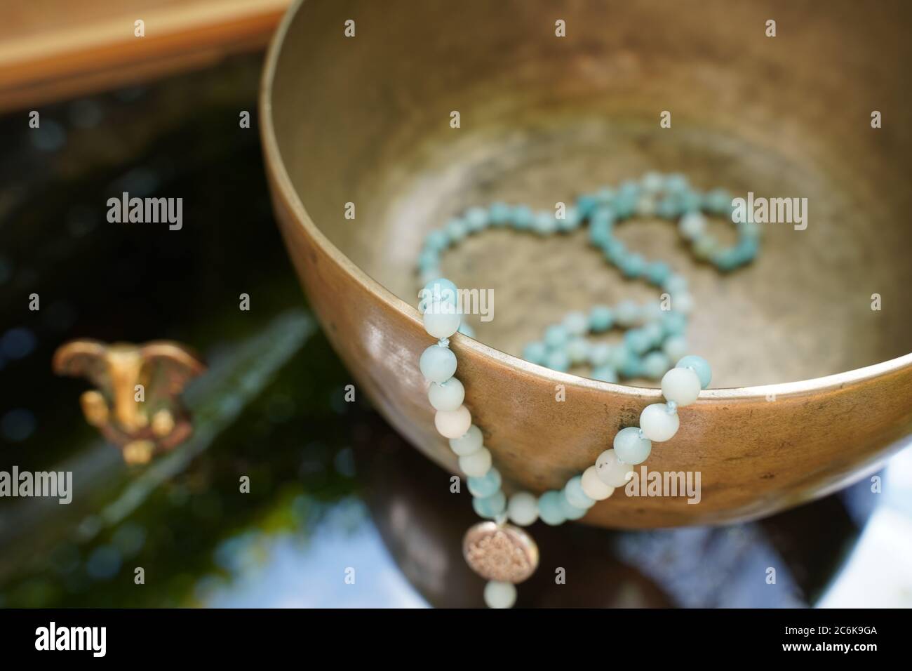 Tibetan singing bowl close up with beautiful turquoise Mala for soundhealing Stock Photo