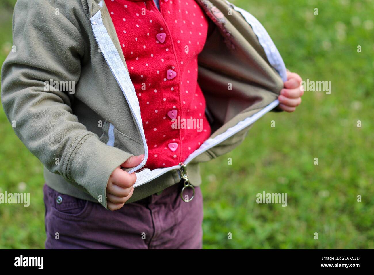 Little children's handles unzip zip on a jacket on a background of