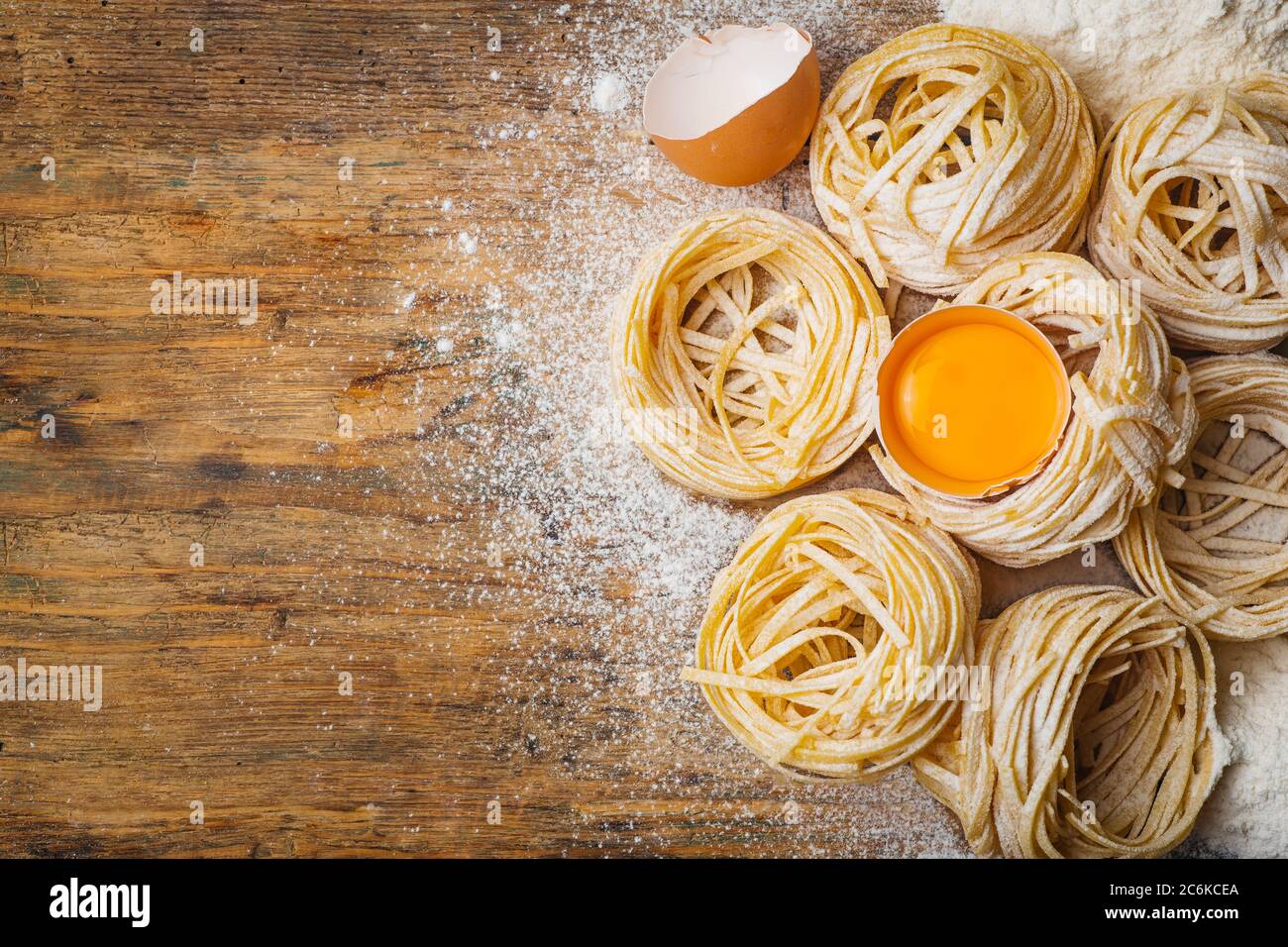 Fresh pasta food. Homemade Italian pasta cooked on a wooden background in a  rustic style decorated with egg and flour Stock Photo - Alamy