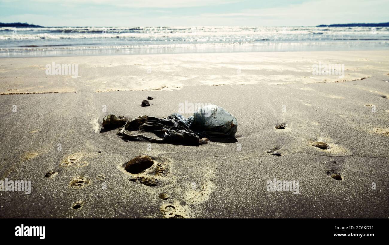Cellophane package on sea beach coast. Environmental pollution. Garbage ...