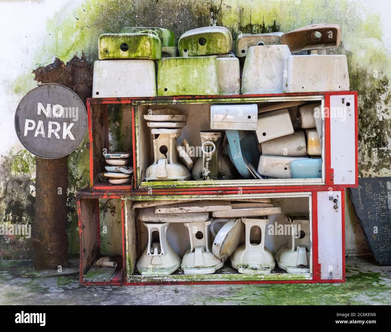 storage of broken porcelain toilets and other stuff... a sign with no park on the left Stock Photo