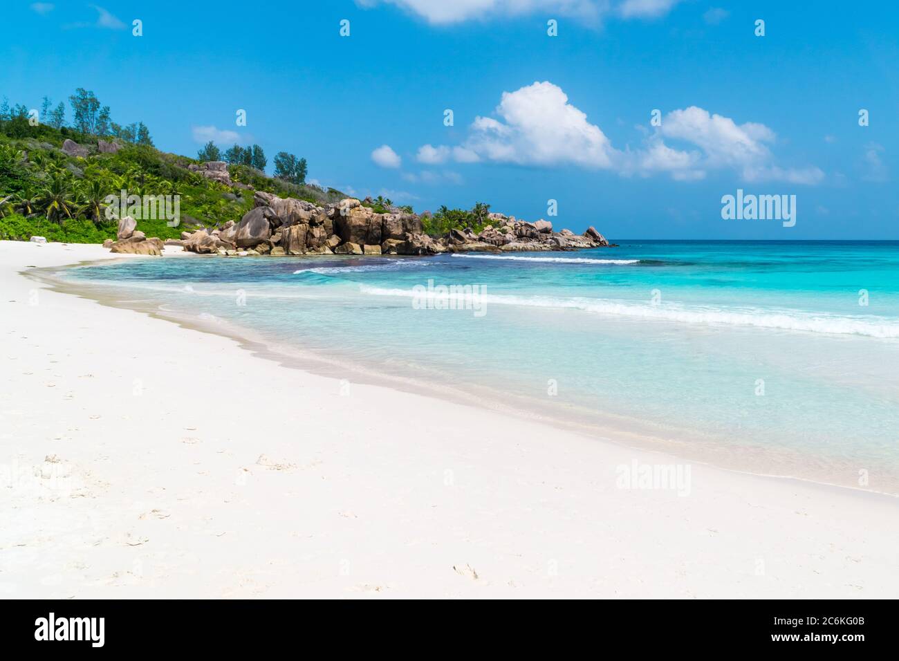 Ocean waves, pristine blue color lagoon and granite rocks on Anse Coco beach, La Digue Island, Seychelles Stock Photo