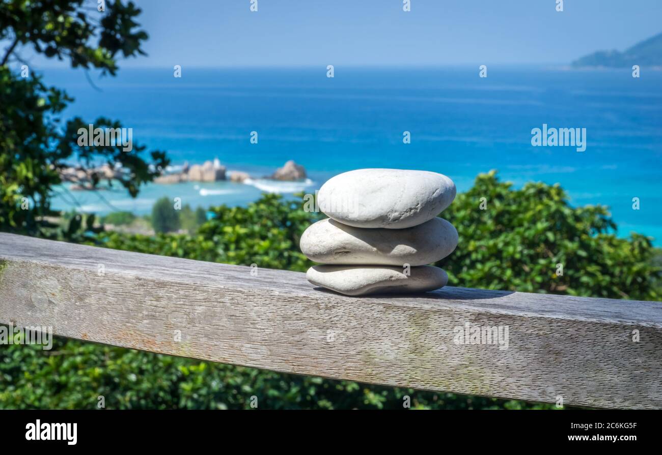 close-up of three white pebbles pilling up on balcony. background with tropcal seascape Stock Photo