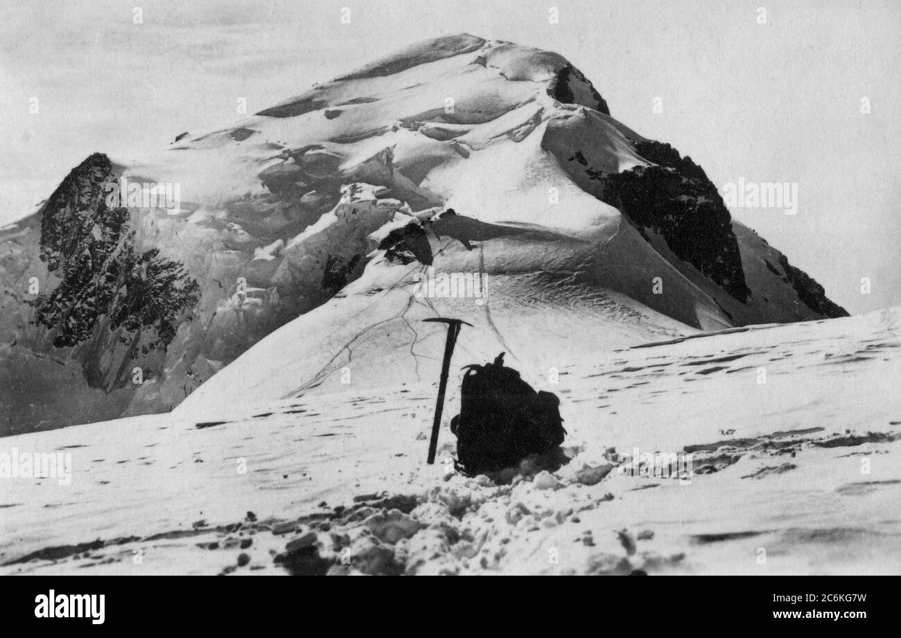 The mountain Mont Blanc with an ice axe and knapsack in the foreground. 1930s Stock Photo