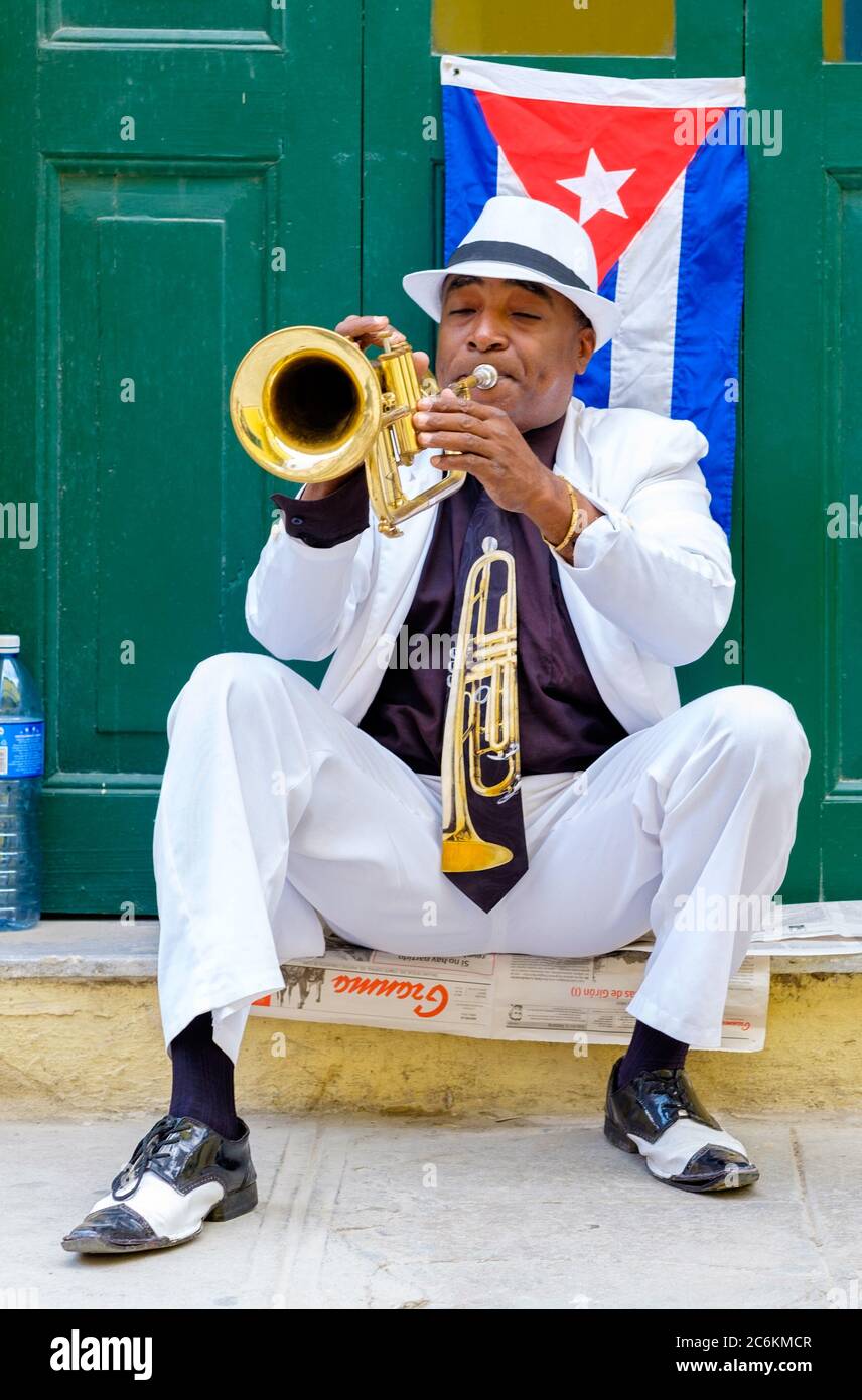 Cuban musician playing the trumpet next to a cuban flag in Havana Stock ...