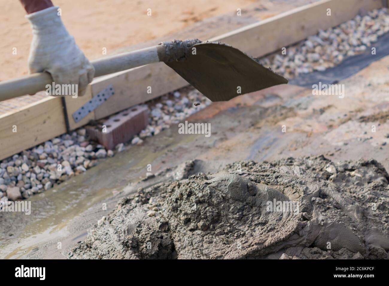 worker mixing concrete and gravel with spade on construction cite Stock