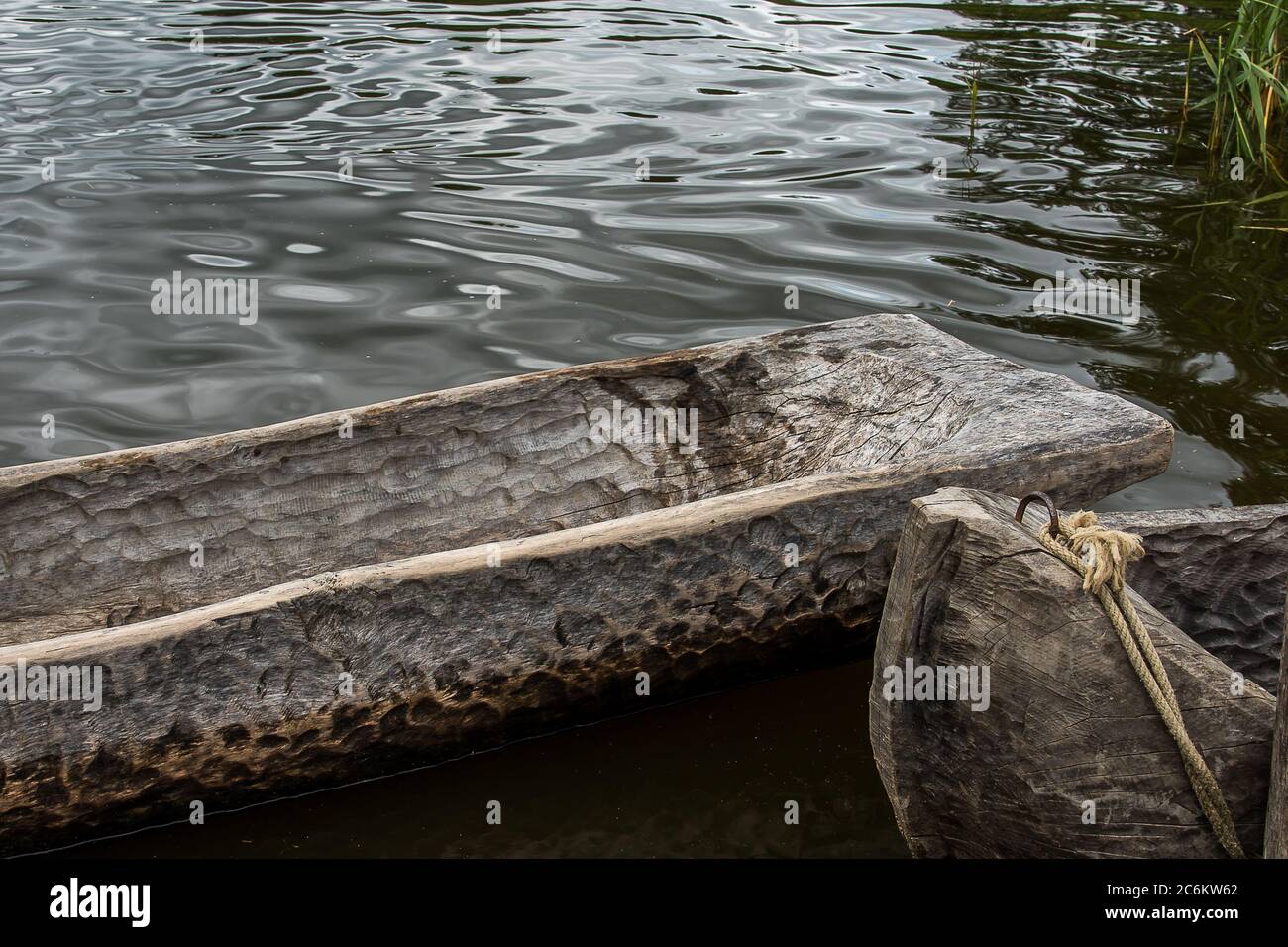 close-up of two dugout canoes made of old oak tree lying in the reflecting water, a Stone Age reconstruction, Lejre Denmark, July 9, 2020 Stock Photo