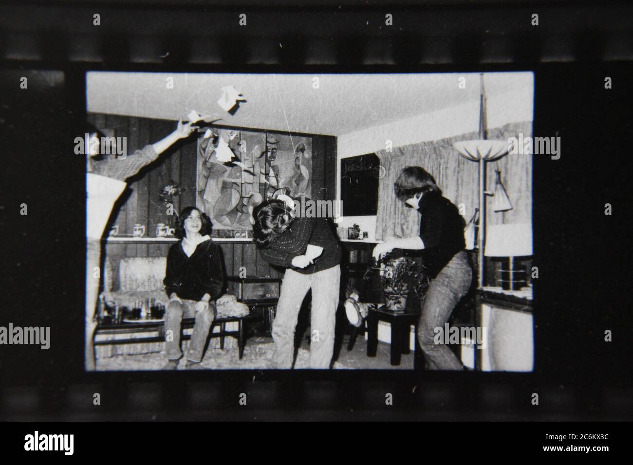 Fine 70s vintage contact print black and white photography of a bunch of teens goofing off at home. Stock Photo