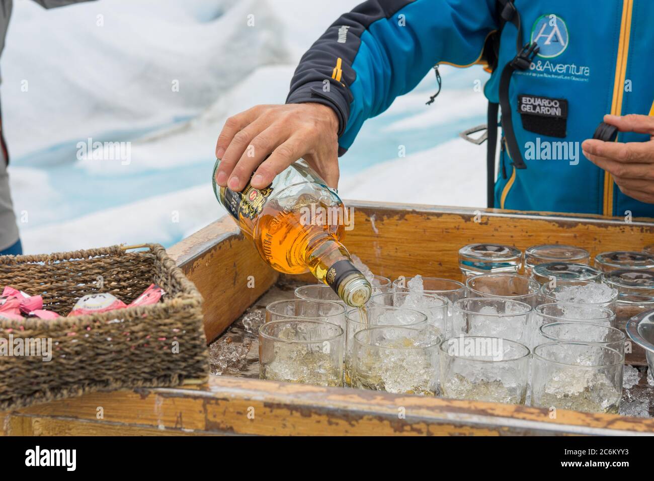 Person serving whiskey in the middle of the mountain Stock Photo