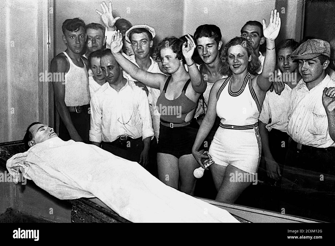 1934 , 22 july, CHICAGO , USA : The american gangster JOHN Herbert DILLINGER ( 1902 - 1934 ), killed by FBI the day 21 july during a fire fighting and exposed at Morgue to young people dress in swimsuit from Lake Michigan summer holidays . In this photo Betty and Rosella Nelson , along with a large crowd, view the body of John Dillinger at the Cook County Morgue , at Polk and Wood Streets, in Chicago . In the days after Dillinger was killed on July 22, 1934, massive crowds lined up outside the morgue to get a glimpse of the notorious public enemy .- CRIMINE - CRIMINALE - CRIME - ASSASSINO - CR Stock Photo