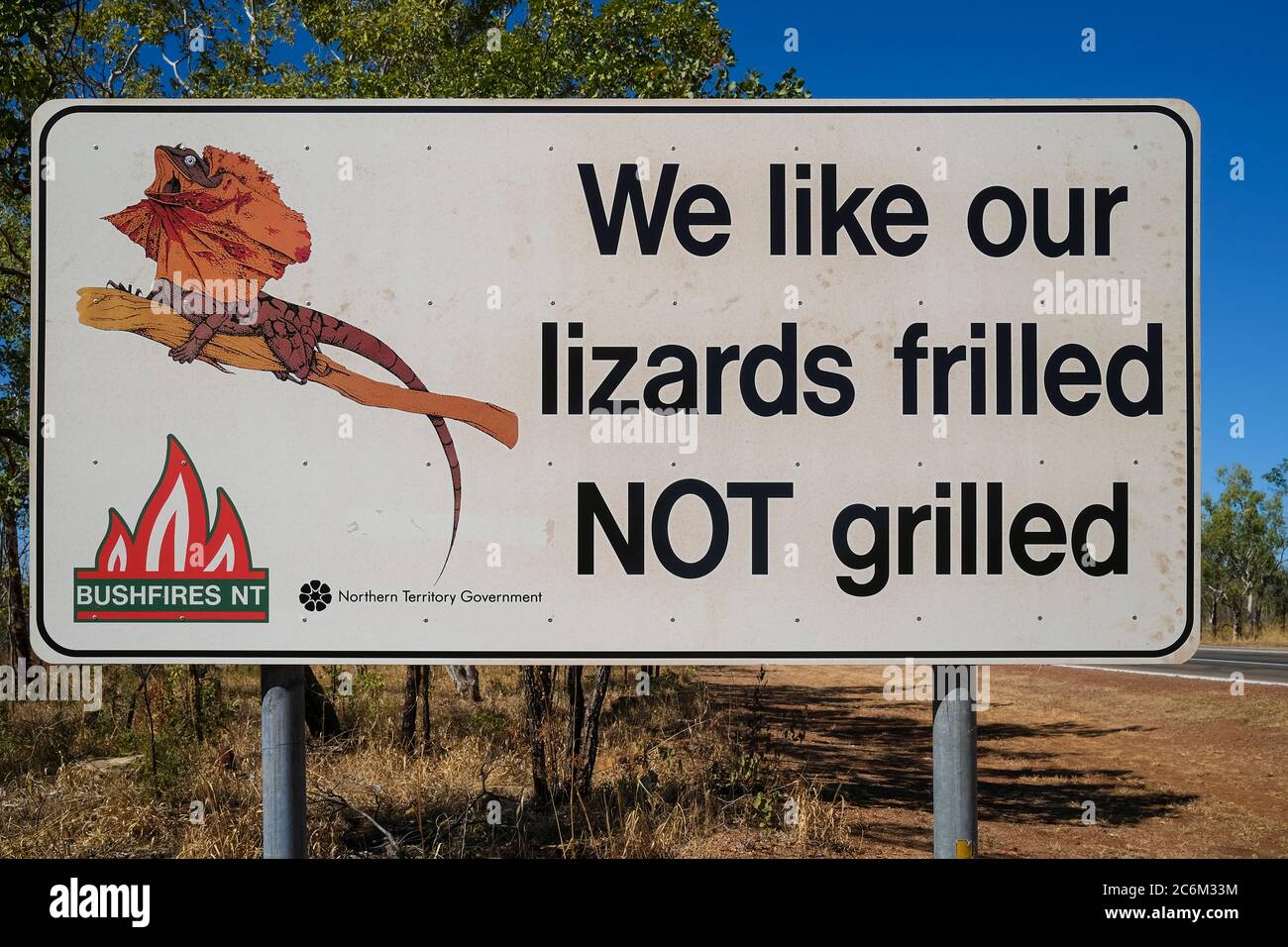 The famous road sign saying: We like our lizards frilled NOT grilled, on the Stuart Highway between Darwin and Katherine in the Northern Territory of Stock Photo