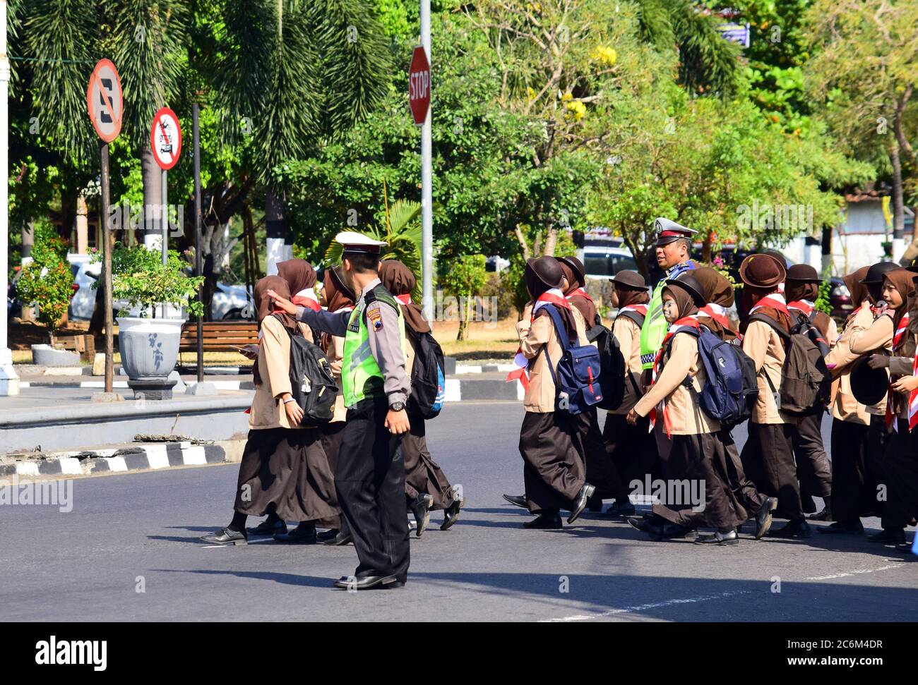 Kendal, Indonesia: 17 August 2019: Police help school children cross the road Stock Photo