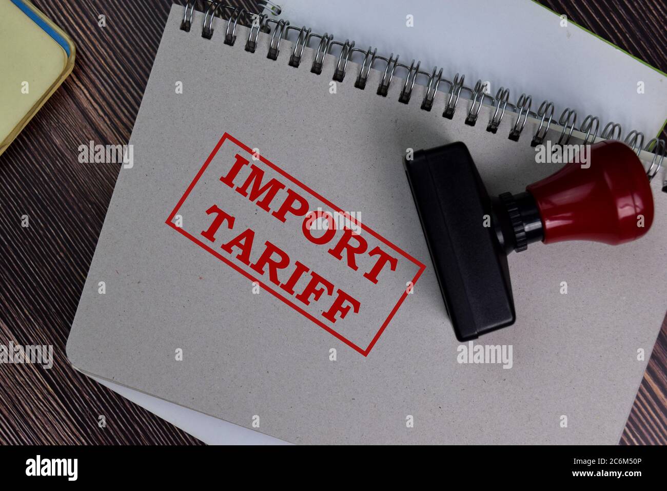 Red Handle Rubber Stamper and Import Tariff text isolated on the table. Stock Photo