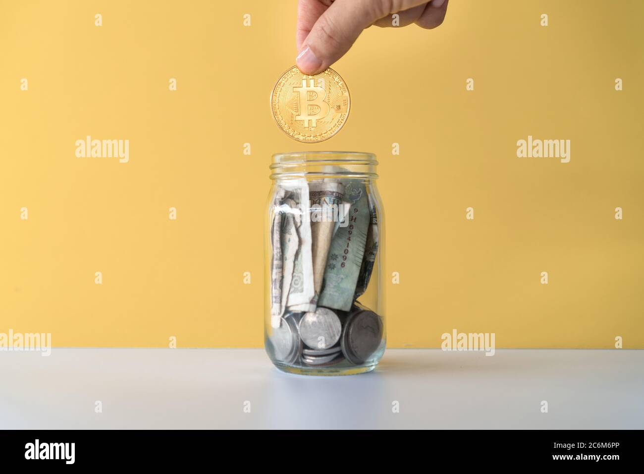 Hand drop gold Bitcoin the jar full of coin and bank notes meaning of  saving investment with cryptocurrency digital money fintech online network.  Busi Stock Photo - Alamy