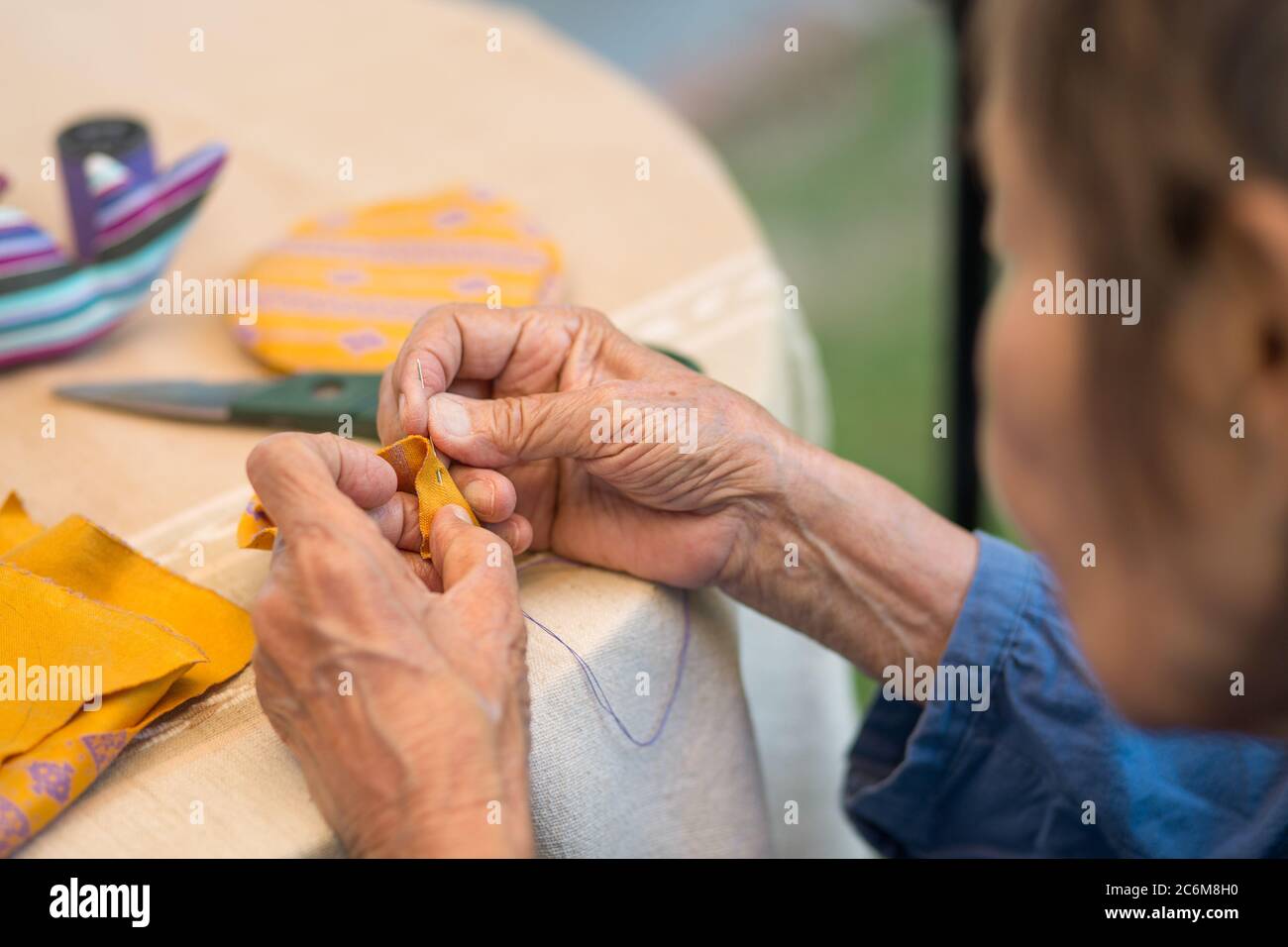 Elderly woman with caregiver in the needle crafts occupational therapy  for Alzheimer’s or dementia Stock Photo