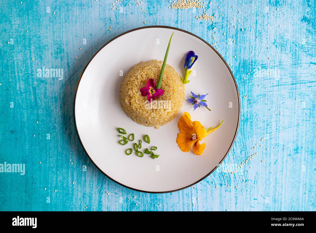 Quinoa plate presentation decorated with edible flowers Stock Photo