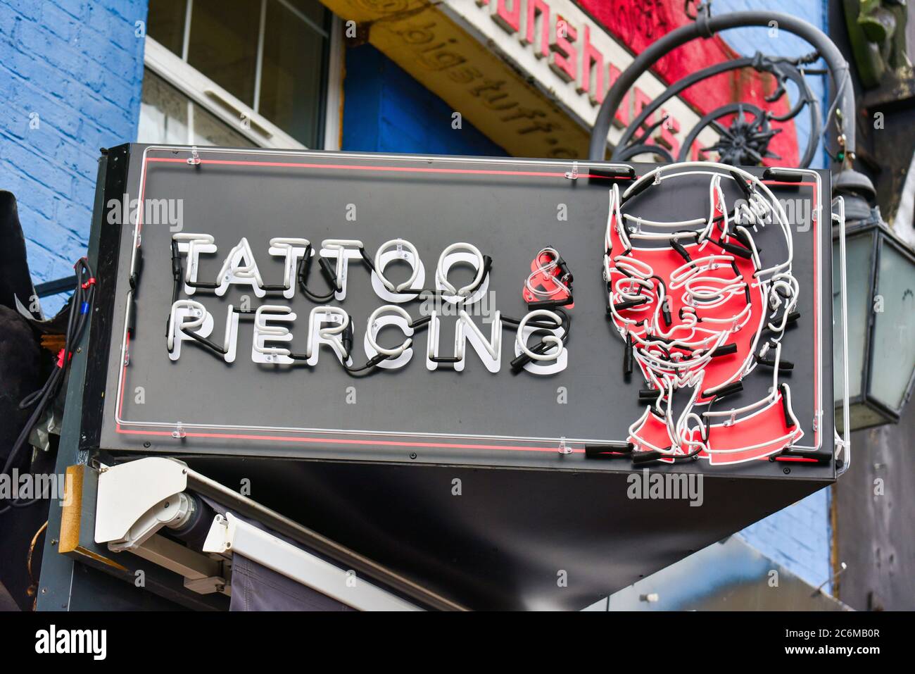 London, UK. 10th July, 2020. A Tattoo and Piercing studio sign in Camden, London. Credit SOPA