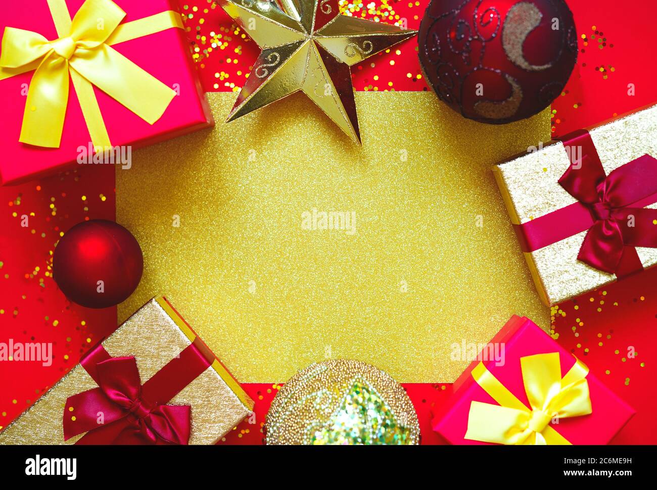 gift boxes with bows and Christmas toys on a red-gold background Stock ...