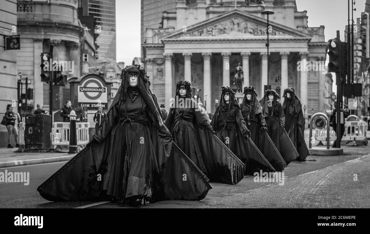 Extinction Rebellion's Black Brigade protest outside the Bank Of England to highlight the bailout of the big corporations. Stock Photo