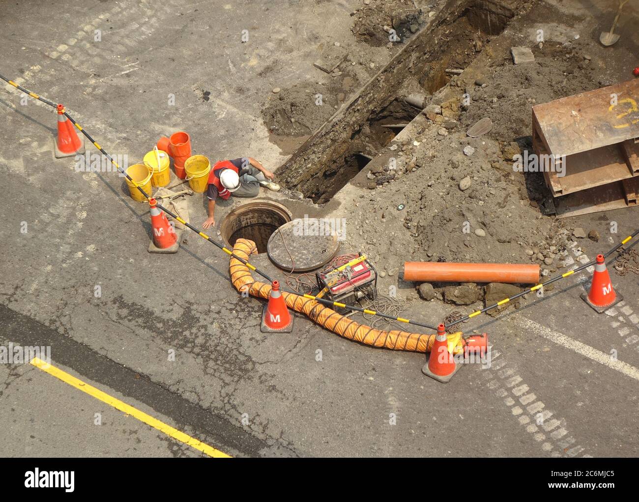 Workers lay new sewer pipes underneath a public road Stock Photo Alamy