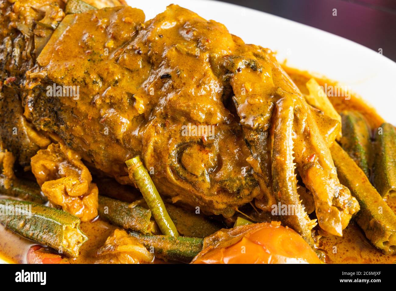 Closeup on serving of curry fish head with okra and tomato, popular