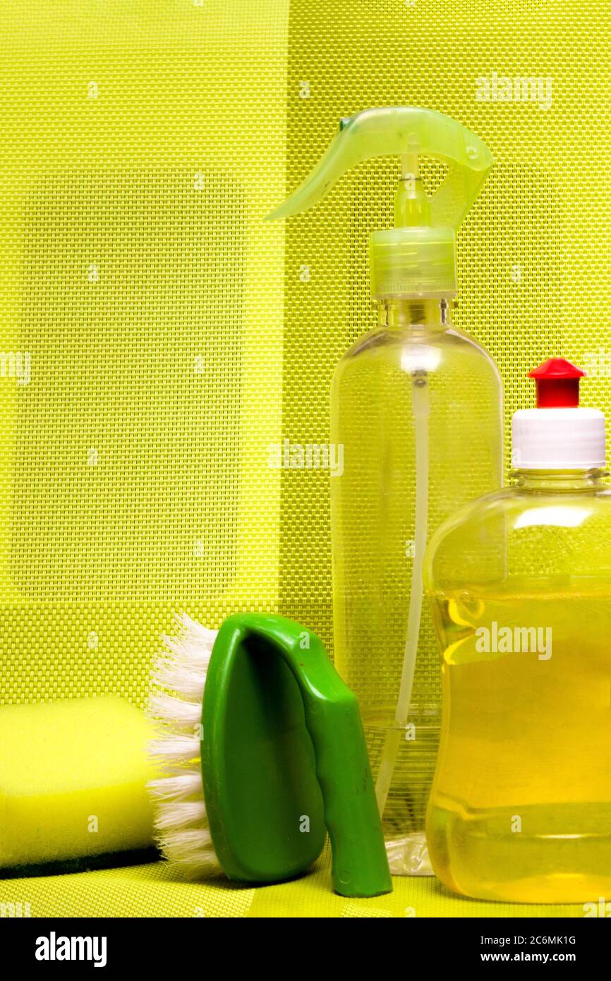 Set for cleaning various surfaces in the kitchen, bathroom and other areas. in yellow on the background . Concept of home cleaning services. Front view. Stock Photo