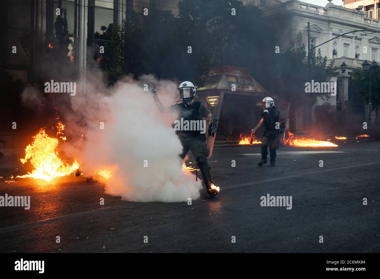 (200711) -- BEIJING, July 11, 2020 (Xinhua) -- Riot police officers respond to petrol bombs with tear gas during protests in Athens, Greece, July 9, 2020. The Greek parliament on Thursday passed a bill regulating public protests amid protests staged by opposition parties and labor unions.   Some 10,000 protesters marched in the center of the capital Athens on Thursday in three separate demonstrations organized by the radical left SYRIZA party, the umbrella union of civil servants ADEDY and the Greek Communist party KKE-affiliated PAME labor union. (Photo by Lefteris Partsalis/Xinhua) Stock Photo