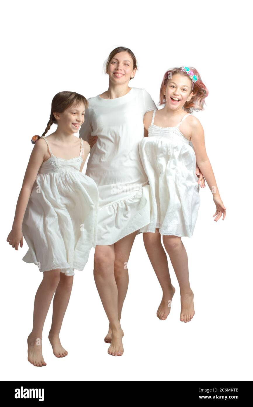 Family mother and two daughters in similar long white dresses. Isolated