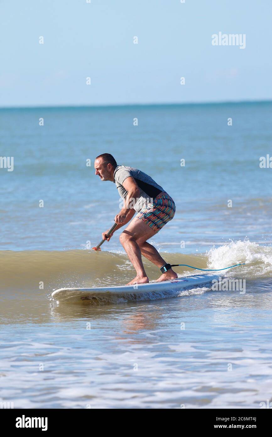 Hastings, East Sussex, UK. 11 Jul, 2020. UK Weather: Beautiful start to the weekend with bright blue sky and warm temperatures in Hastings, East Sussex. A paddle boarder take advantage of the calm waves. Photo Credit: Paul Lawrenson/Alamy Live News Stock Photo