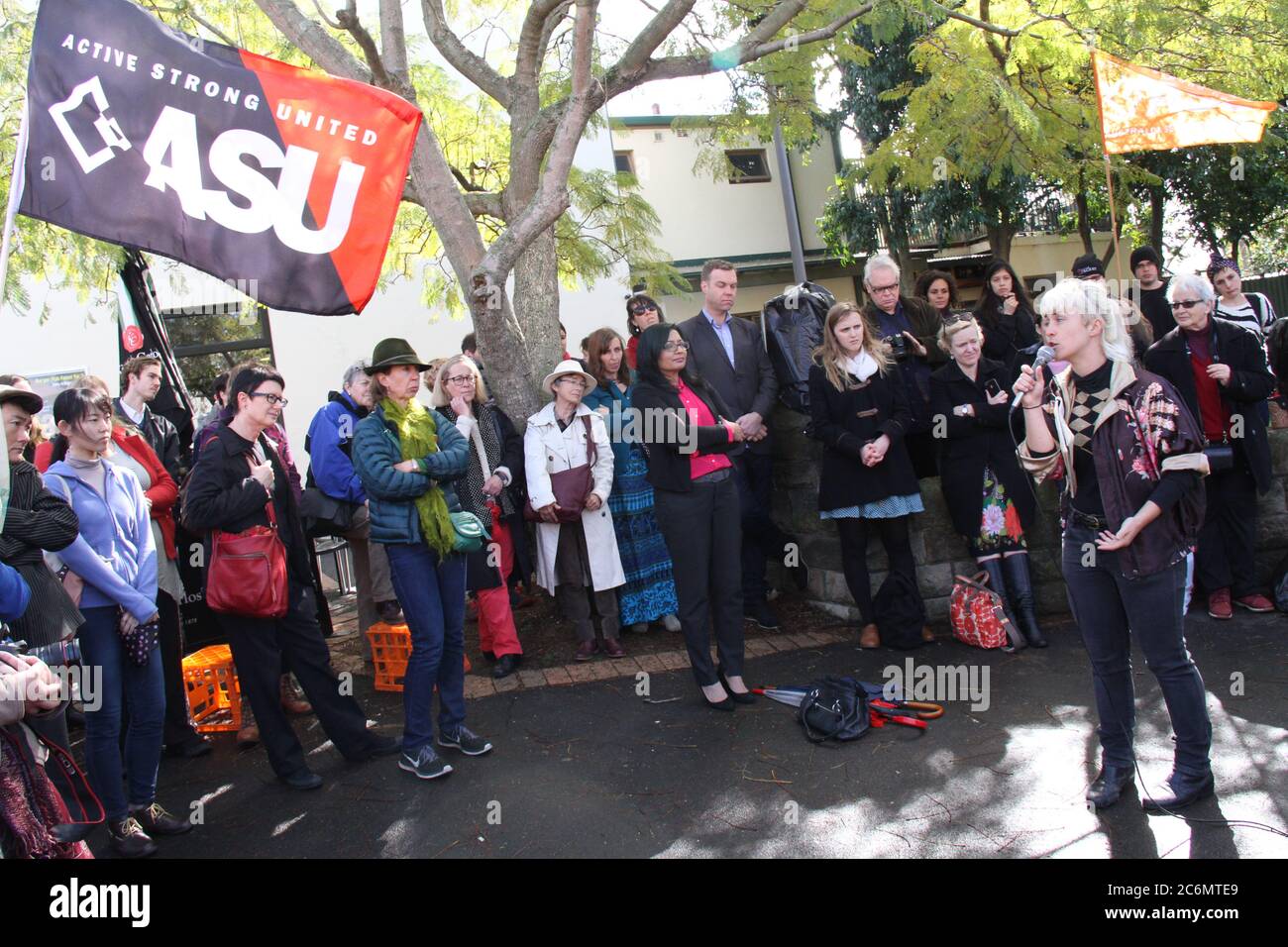 The MC of the rally at Minogue Reserve, Glebe to save women’s refuges from closure speaks to the protesters. Some people held ASU (Australian Services Stock Photo