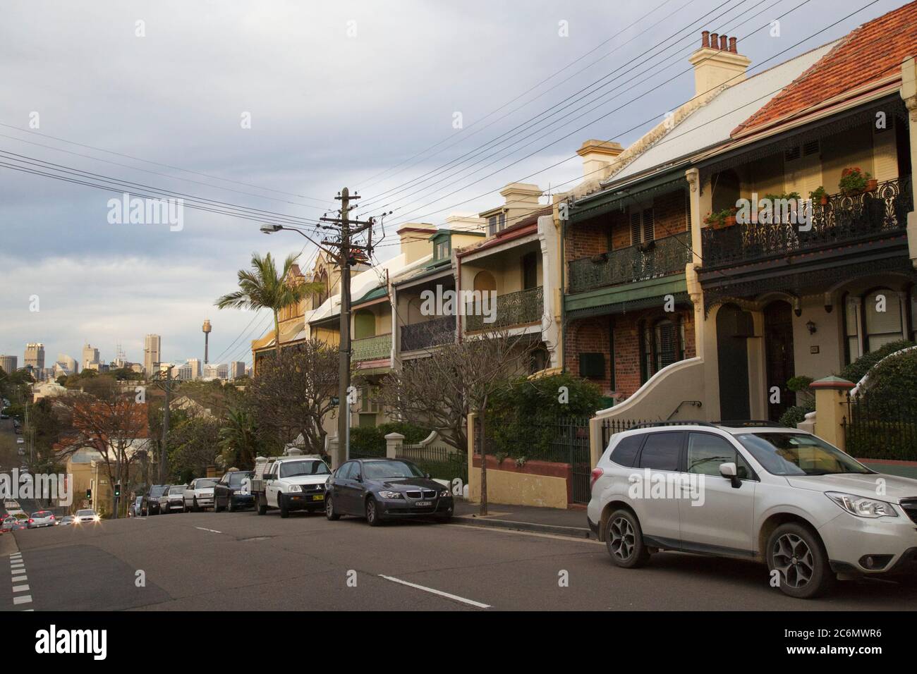 Terraced houses on a hill in Wigram Road, Forest Lodge in Sydney’s inner west, just before sunset, looking towards the Sydney CBD. Stock Photo