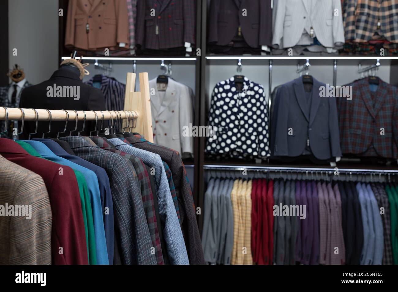 expensive men's clothing store. a row of jackets on hangers. shoping sale background theme. clothes on hanger in shop Stock Photo