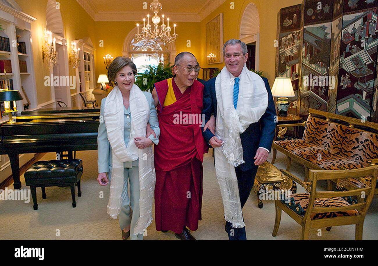 Wearing the traditional white Tibetan scarves presented to them upon his greeting, President George W. Bush and Mrs. Laura Bush walk with the Dalai Lama through the Center Hall of the Private Residence Tuesday, Oct. 16, 2007, at the White House.  Photo by Eric Draper, Courtesy of the George W. Bush Presidential Library Stock Photo