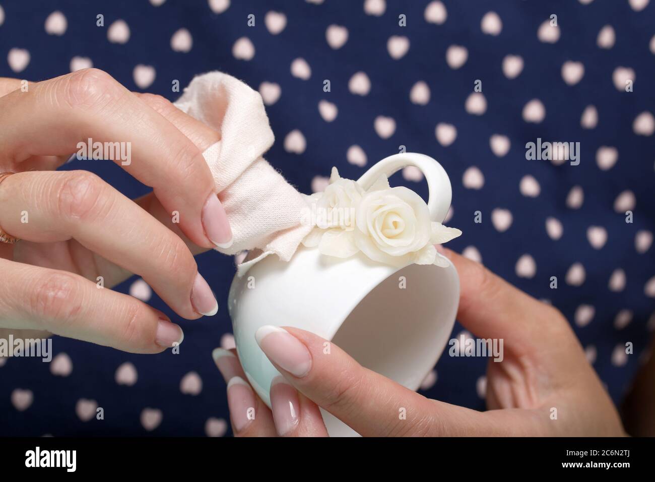 Roses with petals made of white polymer clay. Woman stirs glue with a  brush. Crafts from polymer clay Stock Photo - Alamy