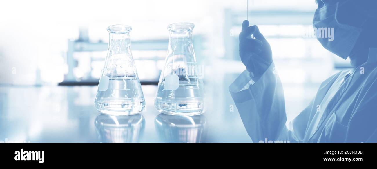 scientist in laboratory coat and two glass flask experimental in health science and technology white blue banner background Stock Photo