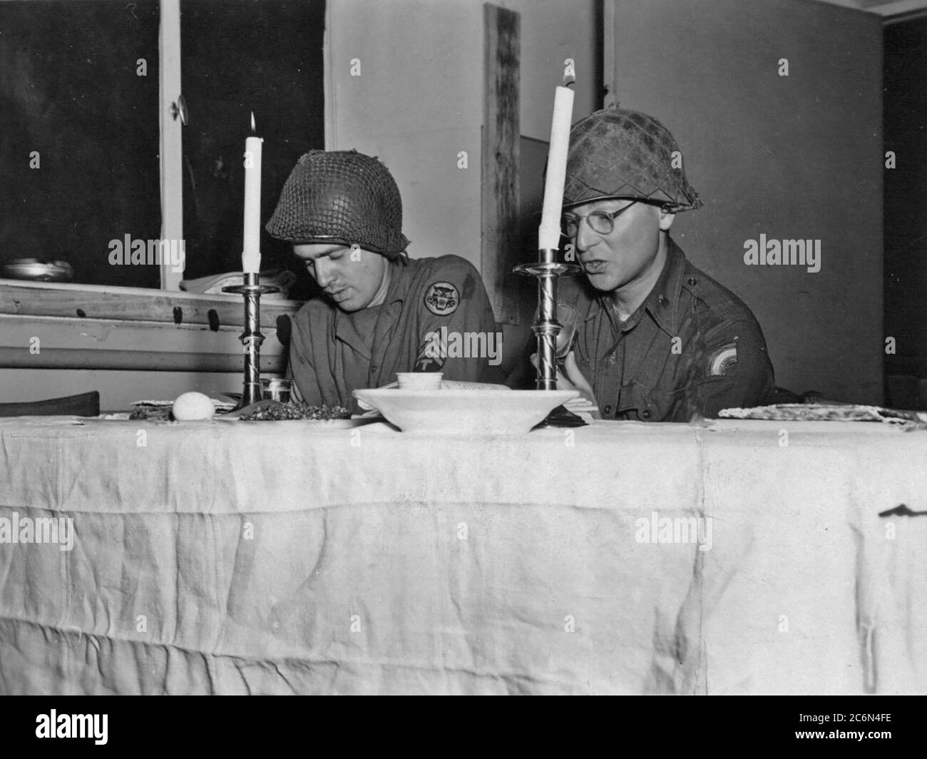 U.S. Army Chaplain (Maj.) Eli Bohnen, right, a rabbi serving with the 42nd Infantry Division in World War II, leads a seder service during the Jewish holiday of Passover in Dahn, Germany March 28, 1945, just over a month before the German surrender. Bohnen and his assistant Cpl. Eli Heimberg created a division Haggadah specifically for the Passover seder. The division Haggadah is believed to be the first Jewish ritual printing in Germany since the rise of the Nazis to power in 1933. U.S. National Guard image courtesy of the 42nd Infantry Division archives. Stock Photo
