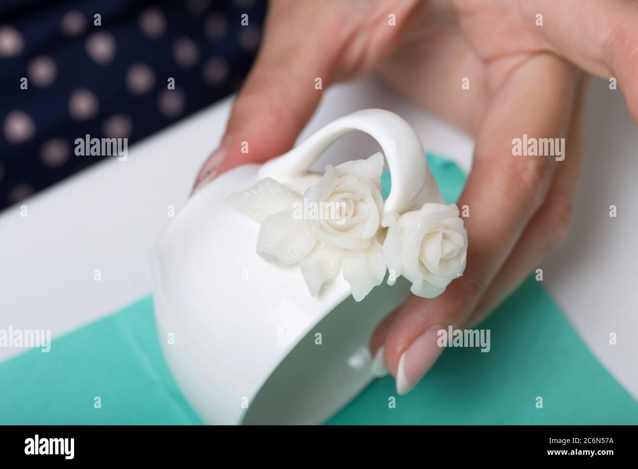 Roses with petals made of white polymer clay. A woman sticks them on a mug.  Crafts from polymer clay Stock Photo - Alamy, image size:1300x956