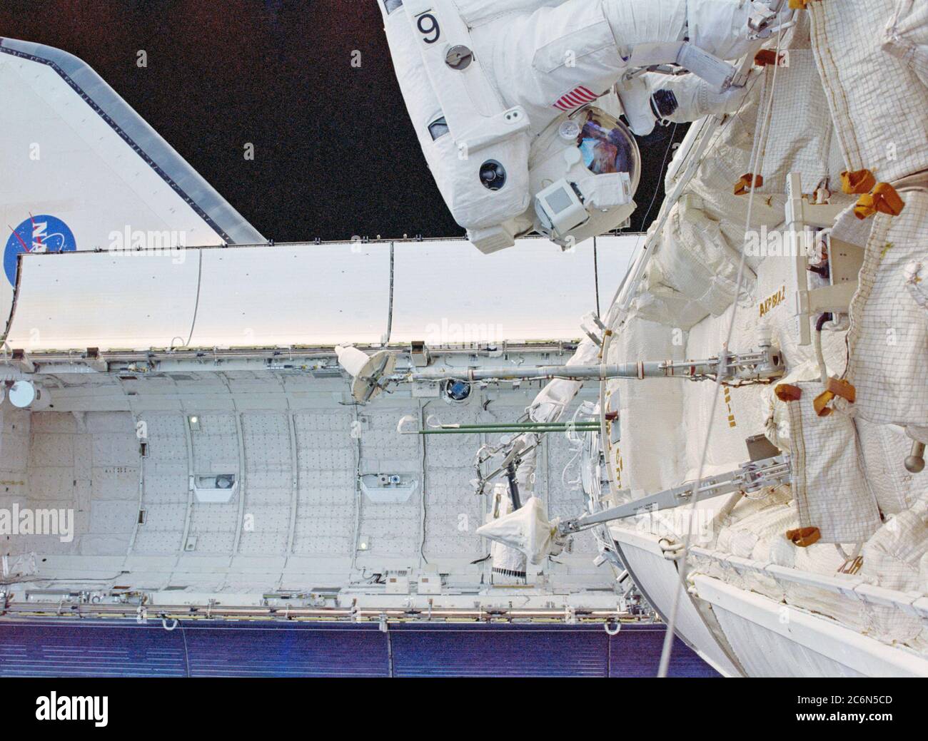 (4-15 Dec. 1998) --- Astronaut James H. Newman, mission specialist, translates along a hand rail on the Russian-built Zarya Module in this Extravehicular Activity (EVA) photograph taken by astronaut Jerry L. Ross, mission specialist.  Ross and Newman shared three space walks altogether to perform cable connection tasks and to put finishing touches on the exteriors of the recently-joined Zarya and the United States-built Unity (Node 1) modules. Stock Photo