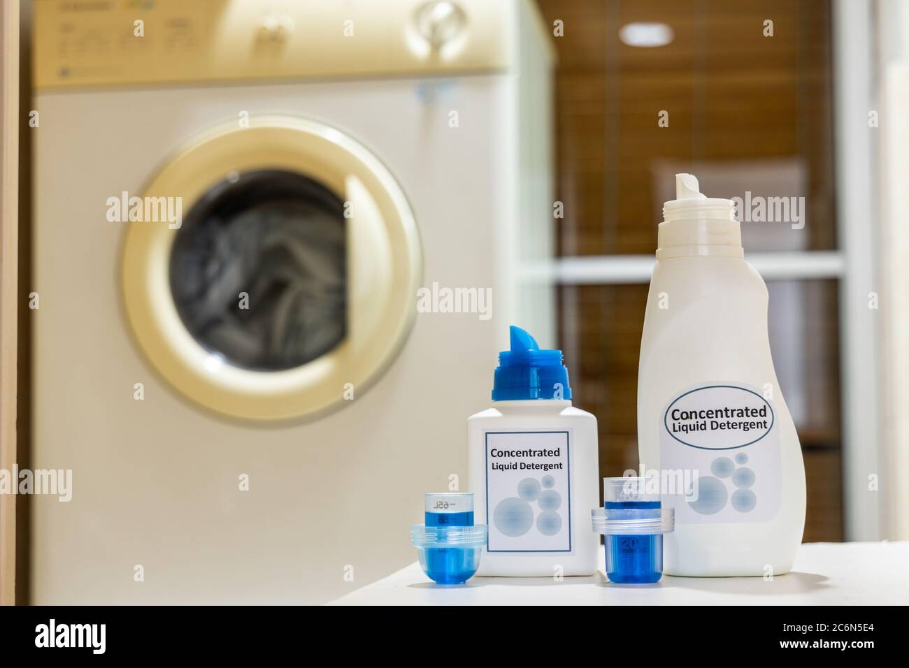 Innovative compact concentrated laundry liquid detergent against washing machine background at home Stock Photo