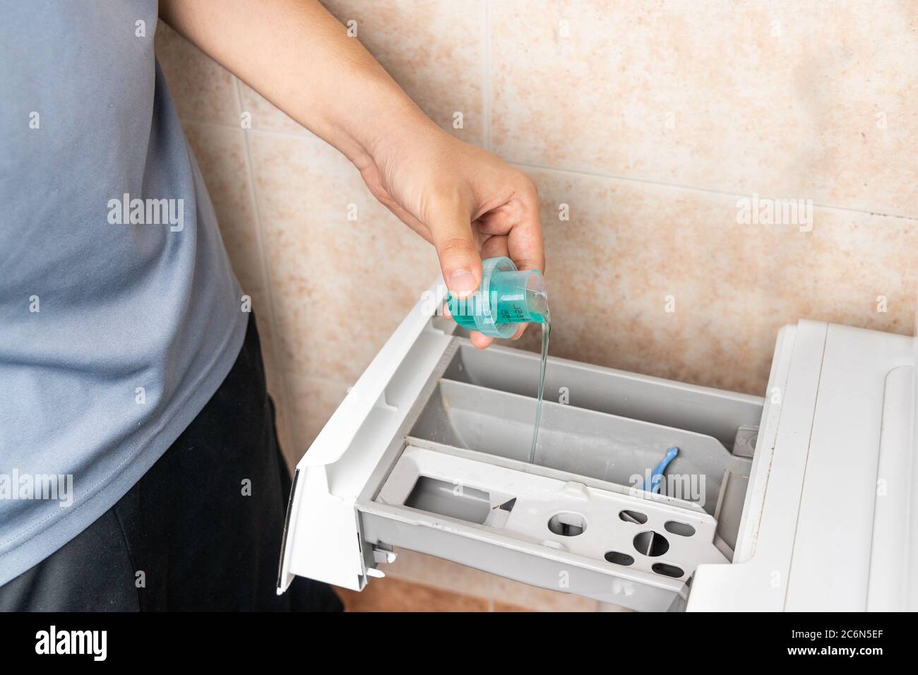Person pouring concentrated compact laundry liquid detergent into