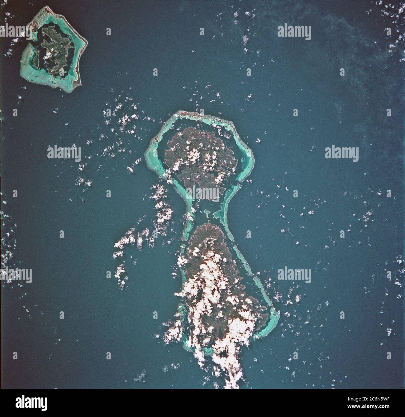 (23-27 July 1999) --- The STS-93 astronauts aboard the Space Shuttle Columbia took this picture featuring the Society Islands.  Delicate coral reefs ring the islands of Bora Bora (top), Tahaa (center) and Raiatea (bottom).  The Society Islands, which also include the island of Tahiti, are one of many archipelagoes that constitute French Polynesia in the central South Pacific. Stock Photo