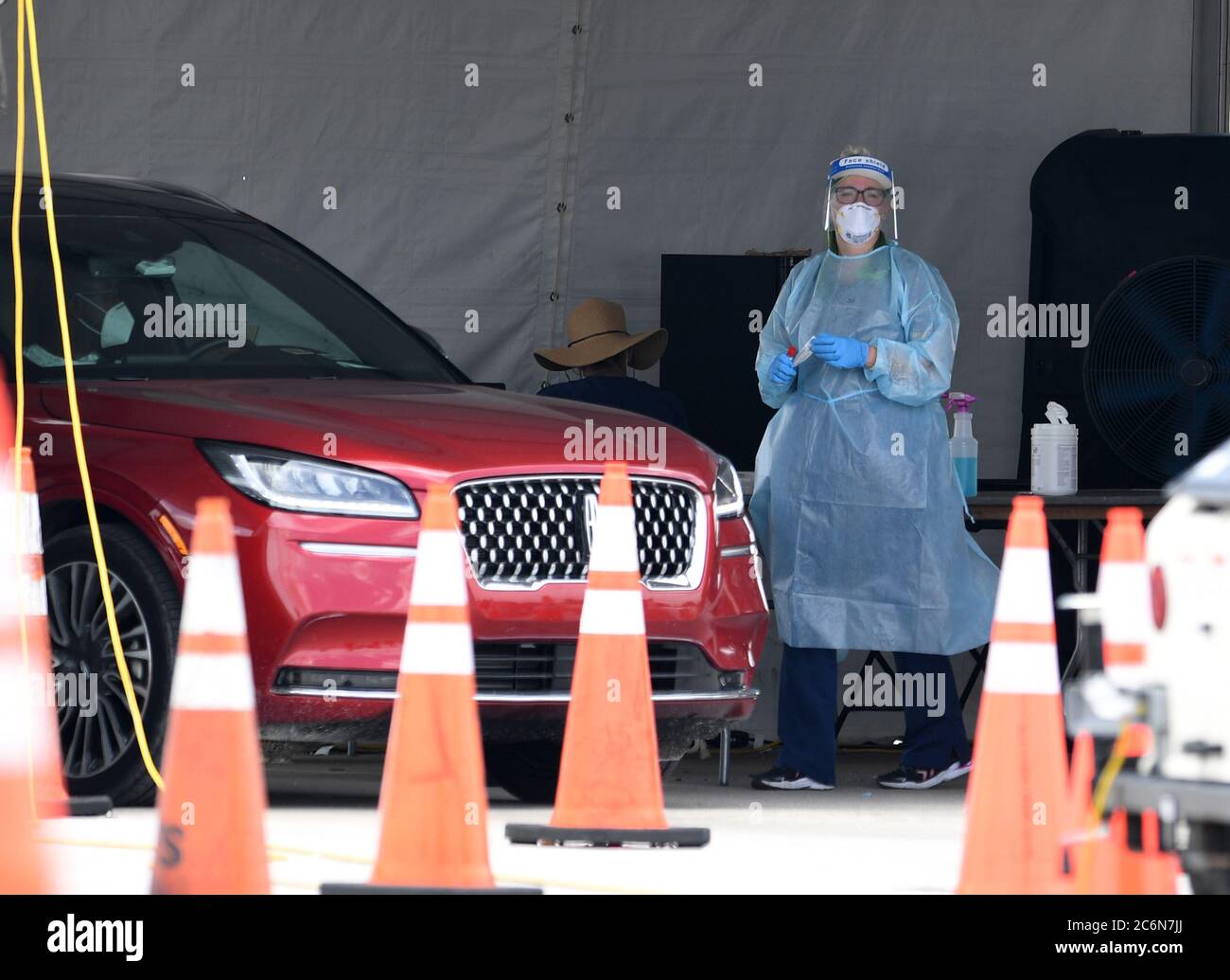 Miami Gardens Beach, FL, USA. 10th July, 2020. A Healthcare worker seen taking a swab sample from a driver at the Coronavirus (COVID-19) drive in testing site, set up in the parking lot of Hard Rock Stadium as Florida reports another record spike 11K in coronavirus cases, Florida's Covid-19 surge shows the state's reopening plan is not working on July 10, 2020 in Miami Gardens, Florida. Credit: Mpi04/Media Punch/Alamy Live News Stock Photo
