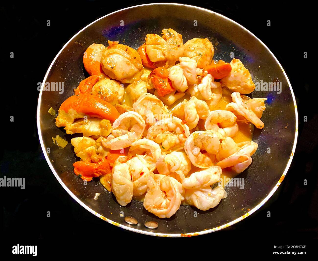 Fresh scallops and prawns being sautéed in garlic butter and herbs fora