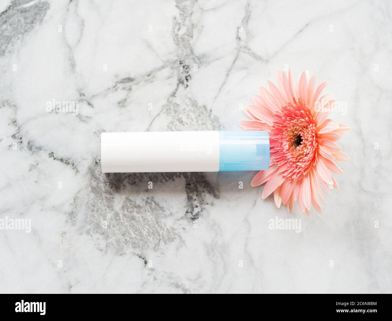 Face moisturizer over pink gerbera on marble Stock Photo