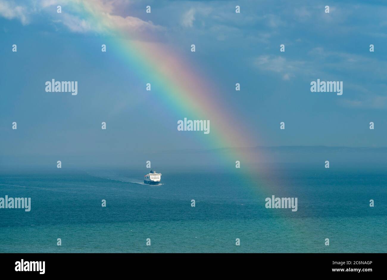 A ferry crossing the English Channel under a rainbow; taken from the cliffs near Dover. Stock Photo