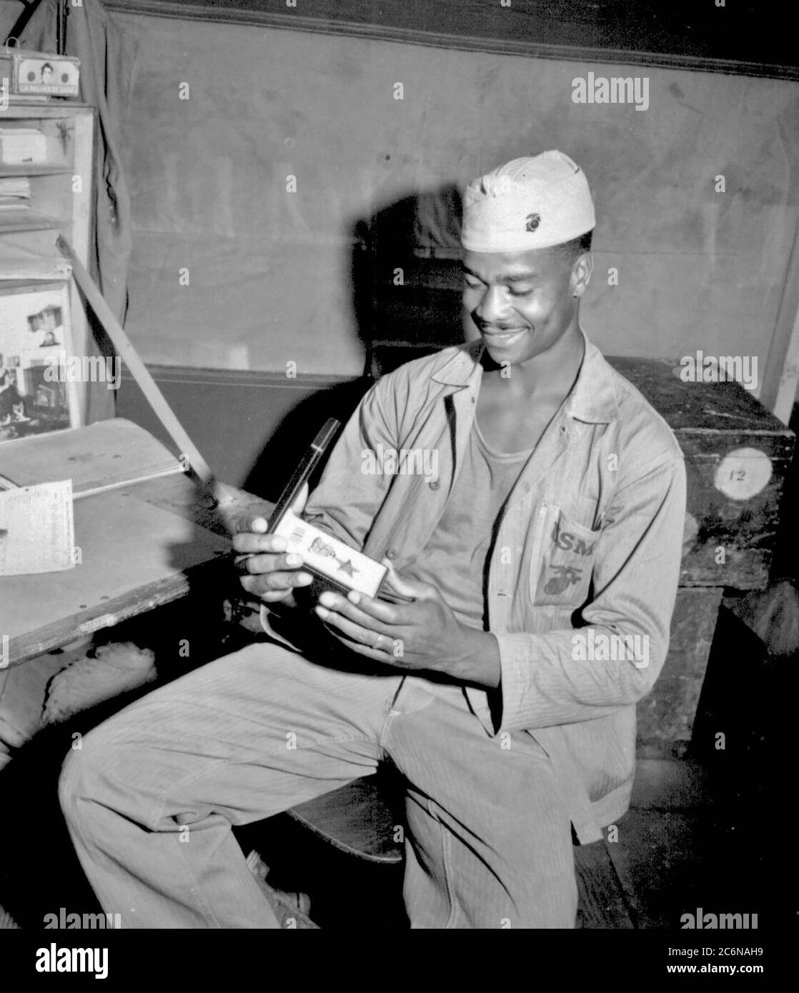 Pfc. Luther Woodward, a member of the 4th Ammunition Company, admires the Bronze Star awarded to him for 'his bravery, initiative and battle-cunning.' The award was later upgraded to the Silver Star, April 17, 1945. (Photo by Cpl. Irving Deutch) Stock Photo