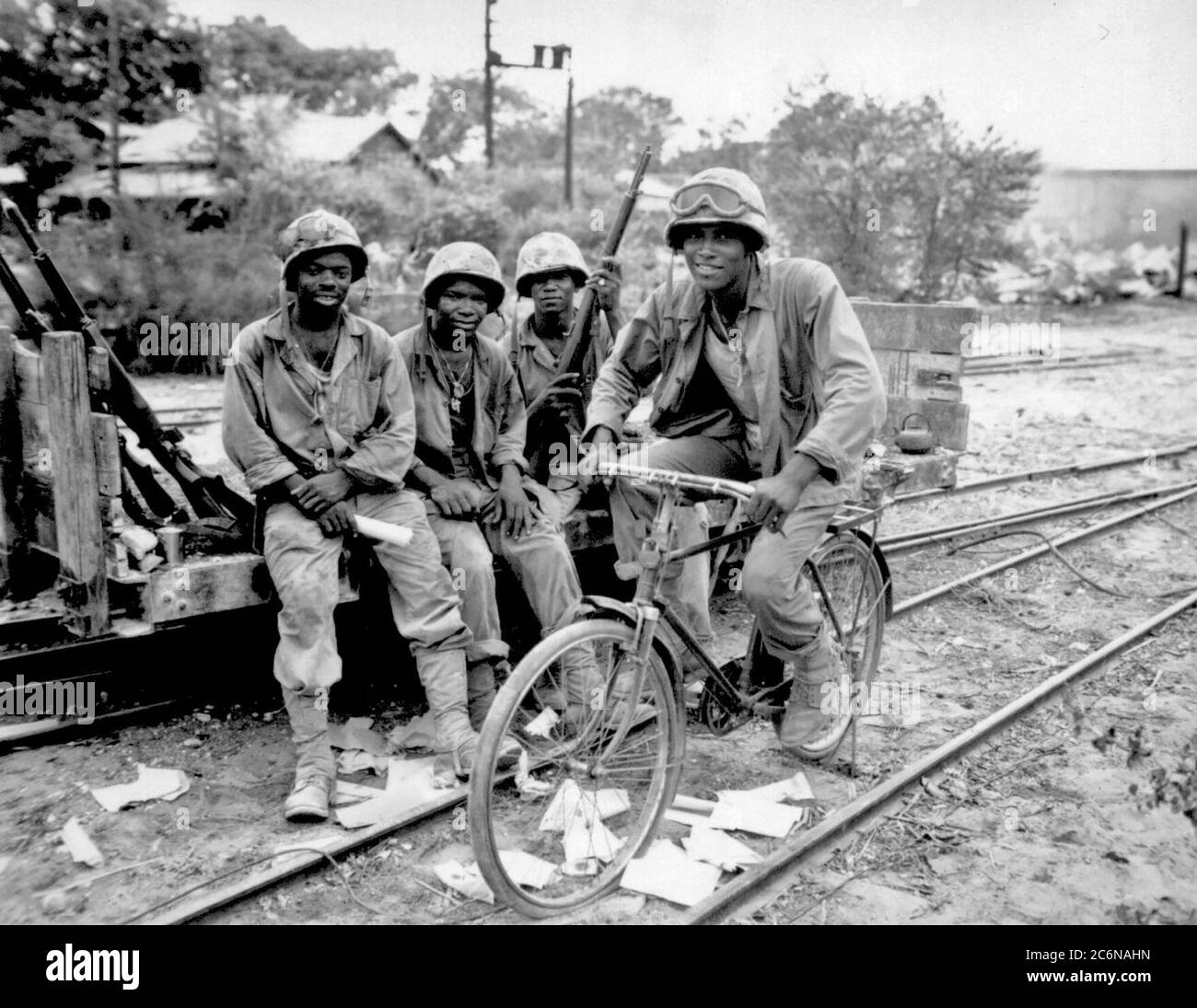 Black Marines, attached to the 3rd Ammunition Company, take time out from supplying ammunition to the front line on Saipan. Riding a captured bicycle is Pfc. Horace Boykin while (left to right) Cpl. Willis T. Anthony, Pfc. Emmitt Shackelford and Pfc. Eugene Purdy watch, June 1944. Stock Photo